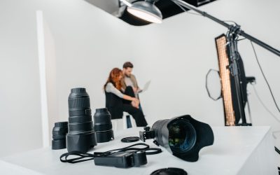 professional photographer and model with laptop in photo studio with digital photo camera, light